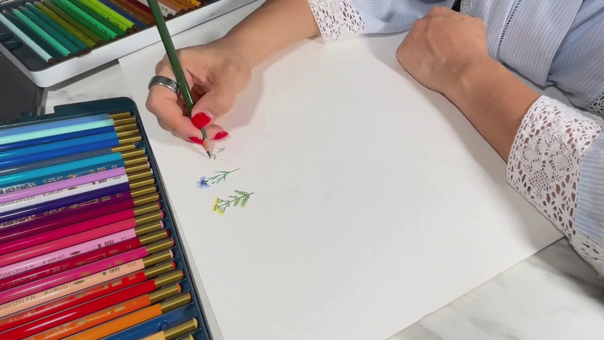 Hands drawing a flower print on paper