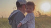 father holding baby looking into the sunrise